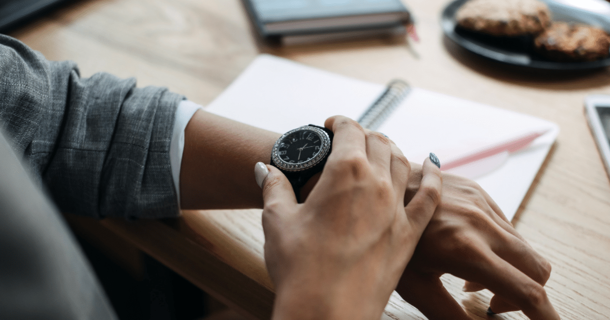 a women at an office desk checking the time while working